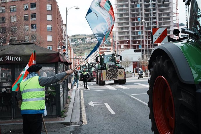 Un hombre apoya a los agricultores con banderas durante una manifestación de tractores en la cuarta jornada de protestas de los ganaderos y agricultores, a 9 de febrero de 2024, en Bilbao, Vizacaya, País Vasco 