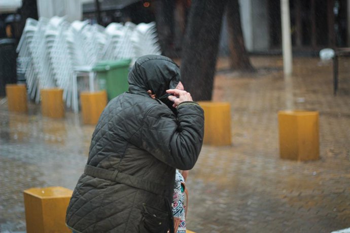 Un viandante se protege de la lluvia 