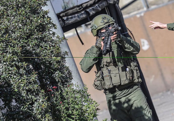 February 8, 2024, Nablus, West Bank, Palestine: An Israeli soldier stands guard near the site where an Israeli soldier shot a Palestinian youth at Israeli Deir Sharaf checkpoint. Palestinian Red Crescent ambulance personnel reported that the soldier who s