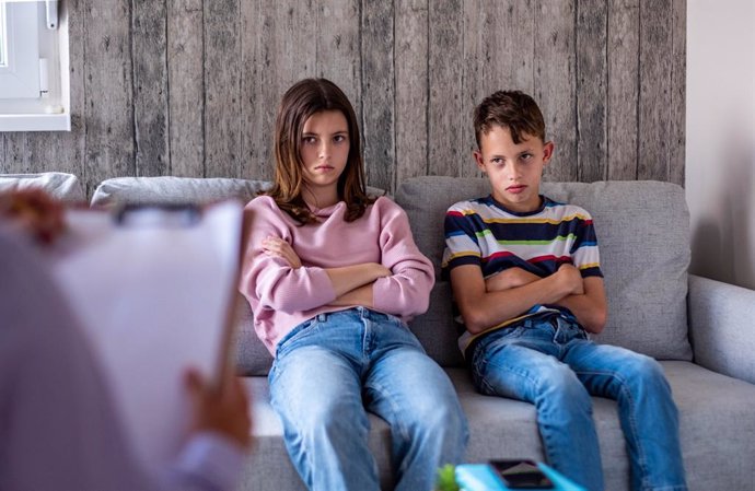 Hermanos adolescentes enfadados en una consulta de Psicología.