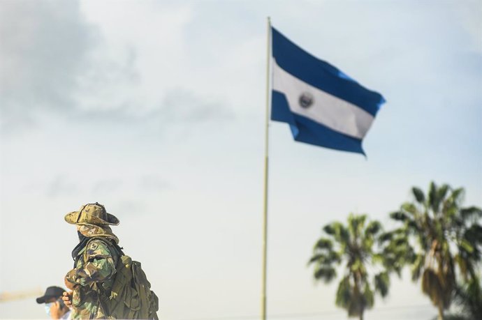 Archivo - June 22, 2021, San Salvador, El Salvador: A war veteran dressed in a military uniform walks by a Salvadoran flag during the demonstration..War veterans demonstrate at the Salvador del Mundo plaza to protest the low pension and health care benefi