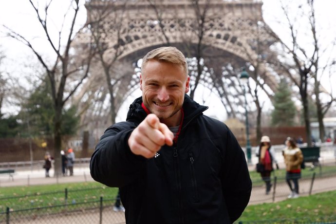 El palista español Marcus Cooper posa delante de la Torre Eiffel a menos de seis meses para los Juegos Olímpicos de París.