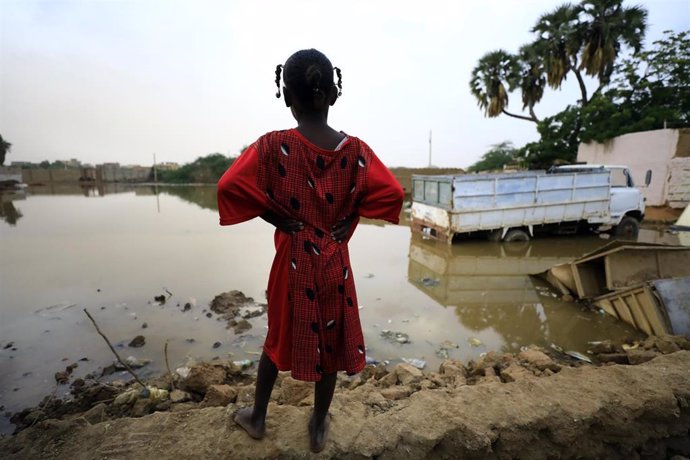 Archivo - Una niña frente a una zona inundada en la capital de Sudán, Jartum (archivo) 