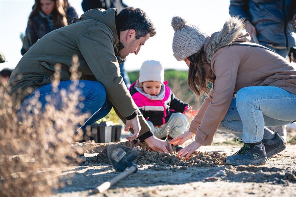Una familia de Aedas Homes poniendo un árbol en la parcela de Cobeña, Madrid