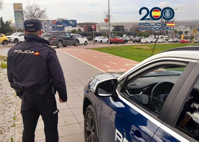 Un agente de la Policía Nacional junto a su vehículo en Jerez.