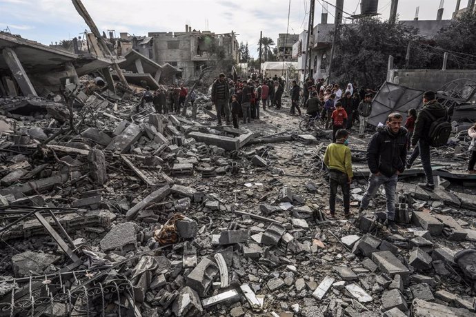 12 February 2024, Palestinian Territories, Rafah: Palestinians inspect damaged residential buildings where two Israeli hostages were reportedly held in Rafah, southern Gaza Strip. The two hostages were rescued as part of an operation that began with heavy