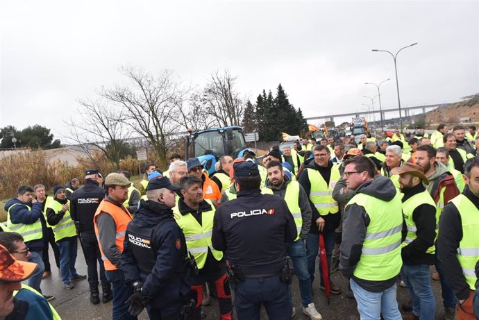 Agentes de Policía Nacional dialogan con los agricultores antes de entrar a Zaragoza por la carretera N-330 durante la cuarta jornada de protestas de los ganaderos y agricultores, a 9 de febrero de 2024, en Zaragoza, Aragón (España). 