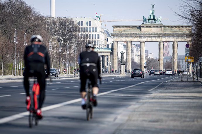 Archivo - 28 March 2020, Berlin: Two cyclists ride on the Strasse des 17. Juni (17th of June Street) in the direction of the Brandenburg Gate. In order to slow down the spread of the coronavirus (COVID-19), the federal government has considerably restri