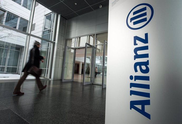 Archivo - FILED - 21 February 2013, Bavaria, Munich: A man walks past the Allianz logo in Munich. Photo: Armin Weigel/dpa