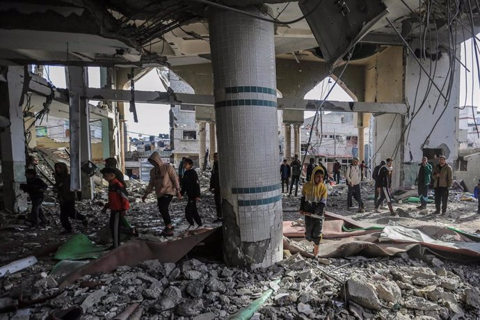 Un grupo de personas inspecciona los escombros de una mezquita destruida en Rafá