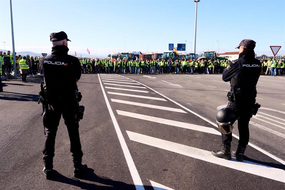 Dos agentes de la Policía Nacional delante de la manifestación de agricultores y tractores en el puerto de Santander