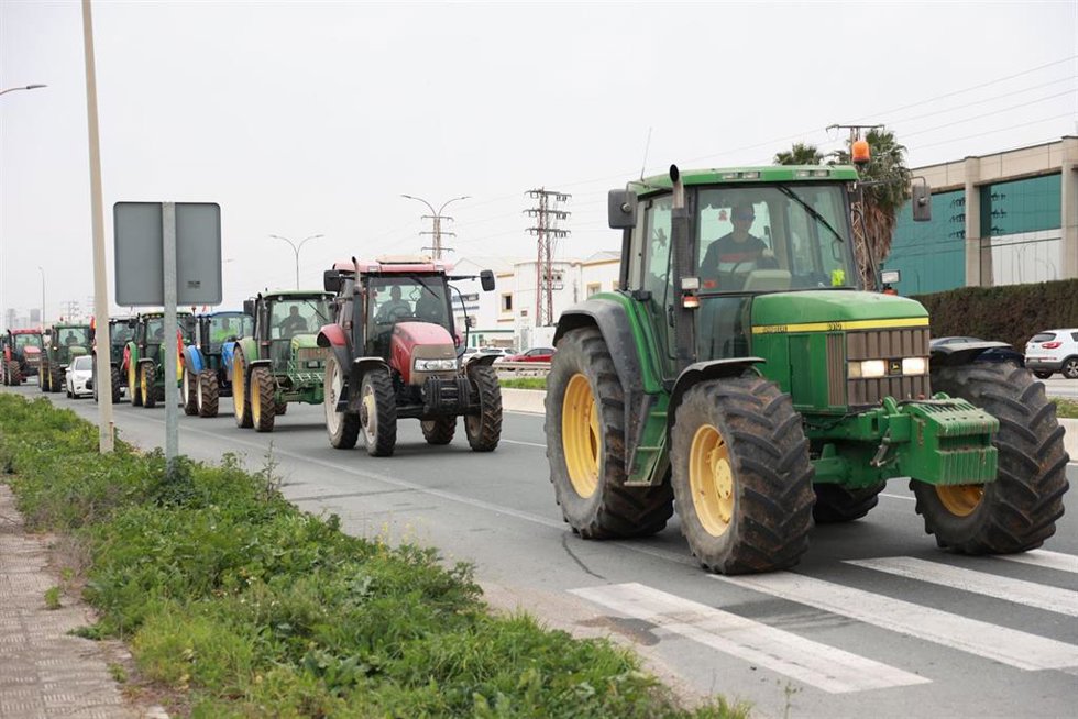 Tractores cortan la carretera SE-3205 de acceso al polígono La Isla de Dos Hermanas.