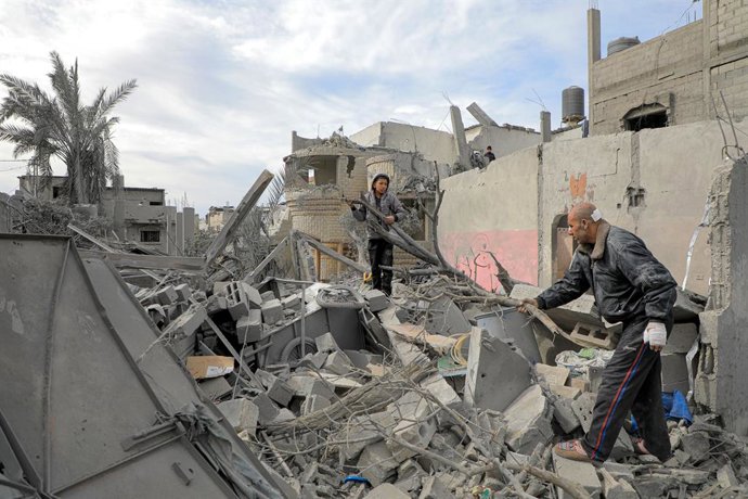 GAZA, Feb. 12, 2024  -- Palestinians check the rubble of a building destroyed in an Israeli air strike in the southern Gaza Strip city of Rafah, on Feb. 12, 2024. More than 100 Palestinians were killed and 160 others injured on Monday in the Israeli arm