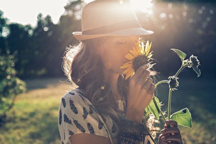 Archivo - Girl smells sunflower