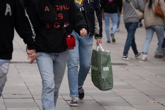 Archivo - Un hombre sujeta una bolsa con compras durante la campaña de Navidad, a 1 de diciembre de 2023, en Barcelona, Catalunya (España). 