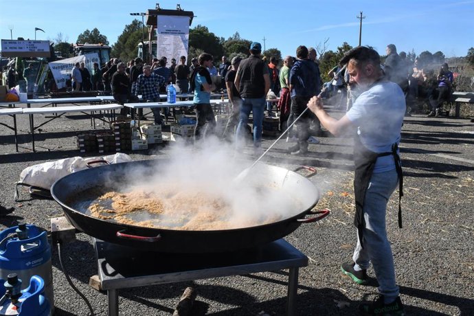Un agricultor hace la comida en una paellera gigante mientras están concentrados en la autopista AP-7 a la altura de Pontós (Girona)