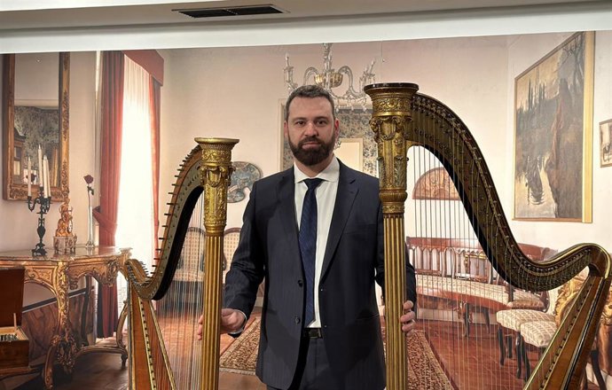El restaurador Víctor Javier Martínez López con dos arpas de la muestra 'De la palabra a la música' en la Casa Revilla.