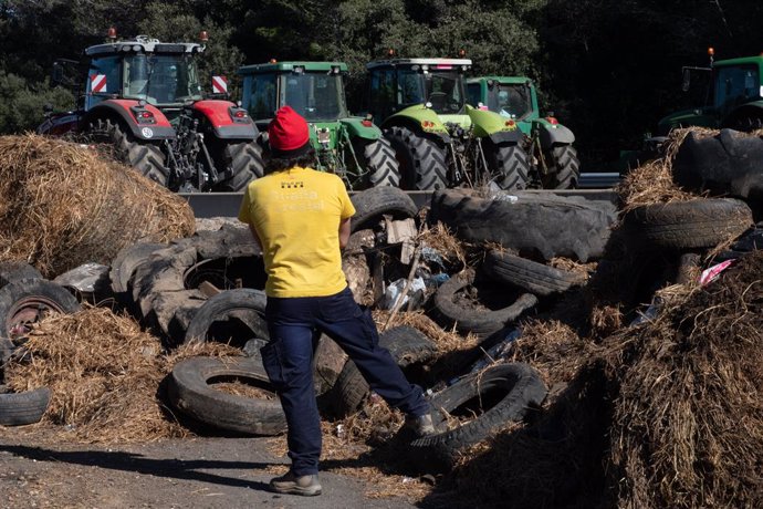 Tractores concentrados al lado de la autopista AP-7 a la altura de Pontós, comen en la novena jornada de protestas de los tractores en las carreteras españolas, a 14 de febrero de 2024, en Pontós, Girona, Catalunya (España). Agricultores y ganaderos de to