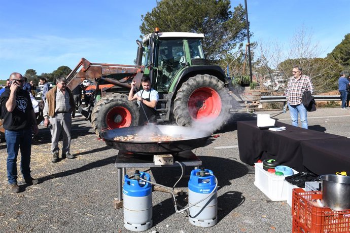 Agricultores hacen la comida en una paellera gigante mientras están concentrados en la autopista AP-7 a la altura de Pontós, en la novena jornada de protestas de los tractores en las carreteras españolas, a 14 de febrero de 2024, en Pontós, Girona, Cata