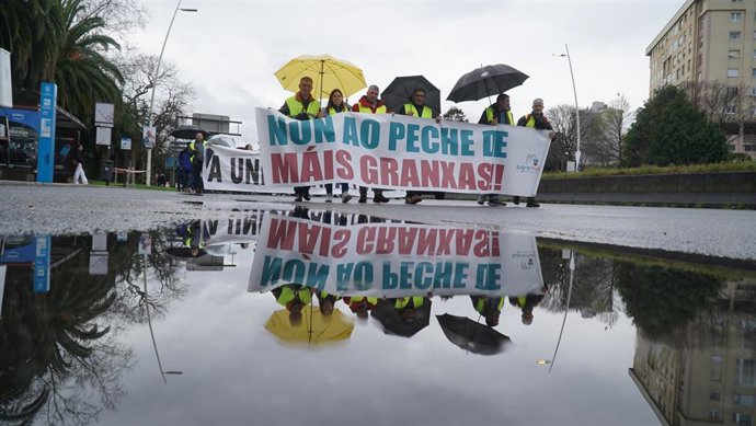 Manifestantes sujetan pancartas durante una protesta en defensa del sector primario, en una protesta convocada por Agromuralla