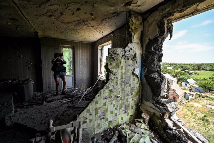 Archivo - Fotógrafo toma una imagen de la destrucción de un edificio alcanzado por un misil ruso en Ucrania