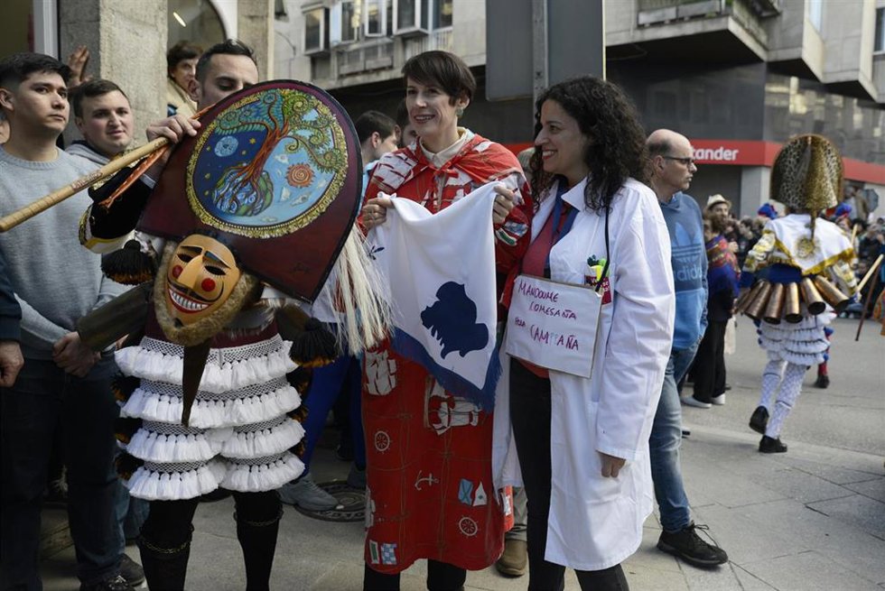 La candidata del Bloque Nacionalista Galego (BNG) a la presidencia de la Xunta, Ana Pontón (c), con una bandera de Galicia regalada por parte de un grupo de "cigarróns", durante su participación en el Entroido de Verín, en la Praza do Concello, a 13 de 