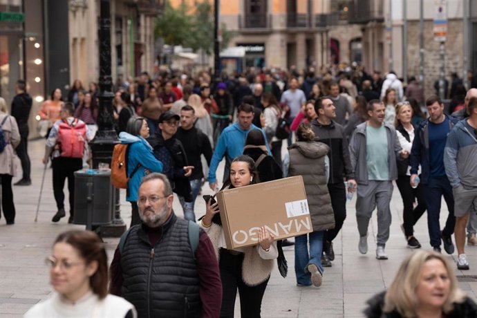Archivo - Una joven sujeta una caja de una tienda de ropa durante la campaña de Navidad, a 1 de diciembre de 2023, en Barcelona, Catalunya (España). 