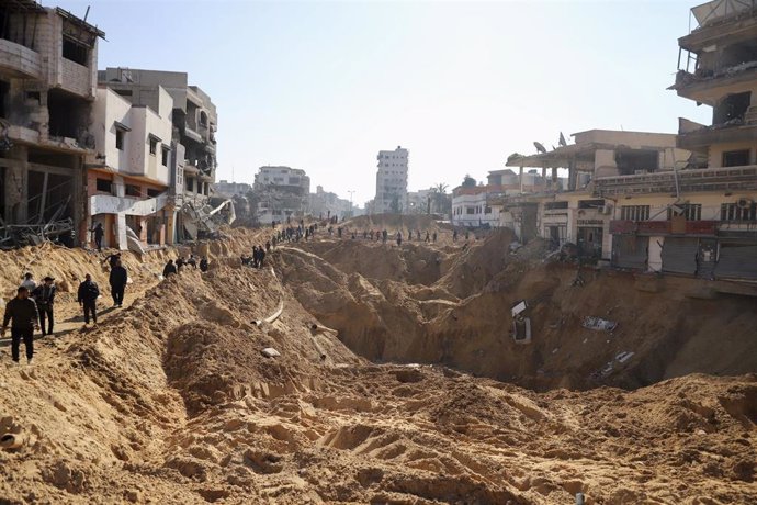 GAZA, Feb. 11, 2024  -- People walk past damaged buildings in Gaza City, Feb. 10, 2024.   The Palestinian death toll from the ongoing Israeli attacks on the Gaza Strip has exceeded 28,000, the Gaza-based Health Ministry said Saturday.