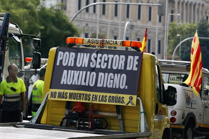 Archivo - Una grúa con un cartel en el que se lee: 'Por un sector de auxilio digno'