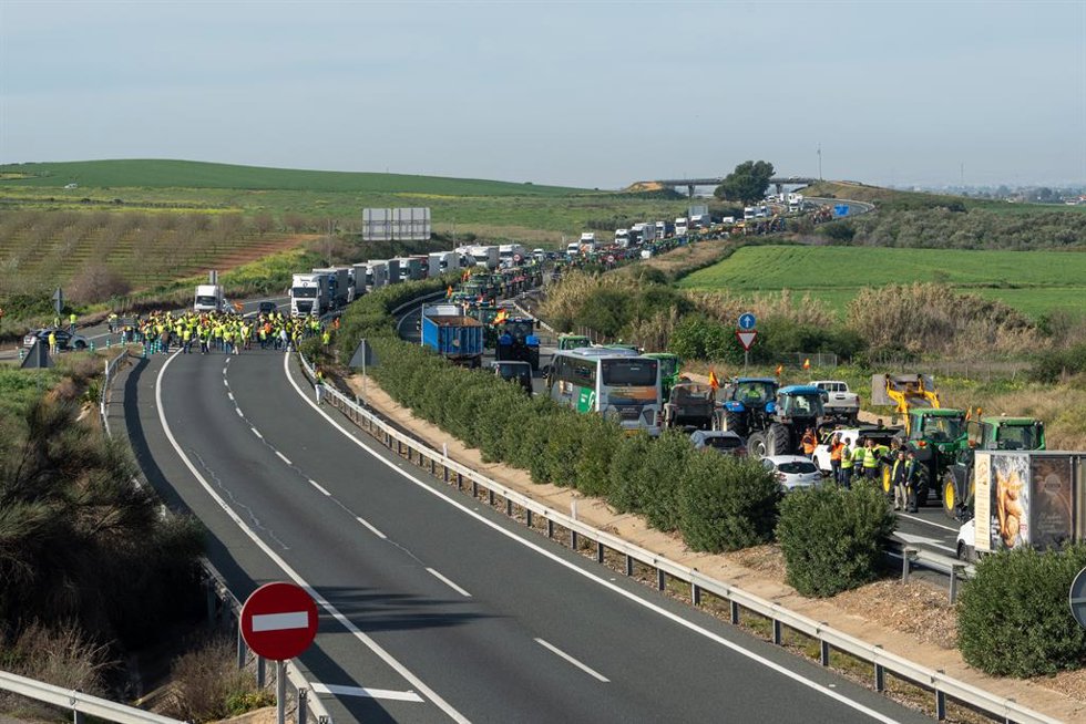Tractores y agricultores cortan la A-4 en ambas direcciones, a la altura del término municipal de Carmona., a 14 de febrero de 2024, en Sevilla, (Andalucía, España). Agricultores convocados por Asaja, COAG, UPA y Cooperativas Agroalimentarias se concent