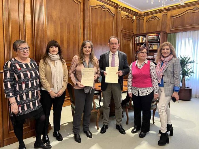 En el centro, Monserrat Martínez y Benito Serrano con el convenio de colaboración