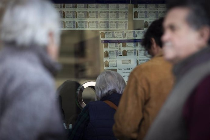 Archivo - Varias personas hacen cola para comprar lotería, en imagen de archivo. 