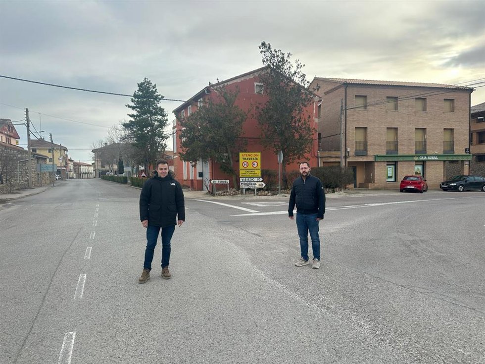 El alcalde de Perales del Alfambra (Teruel), Pedro Polo, y el diputado autonómico del PSOE, Ángel Peralta, en la zona donde quieren que se construya una rotonda para distribuir el tráfico de dos vías autonómicas que atraviesan el casco urbano.