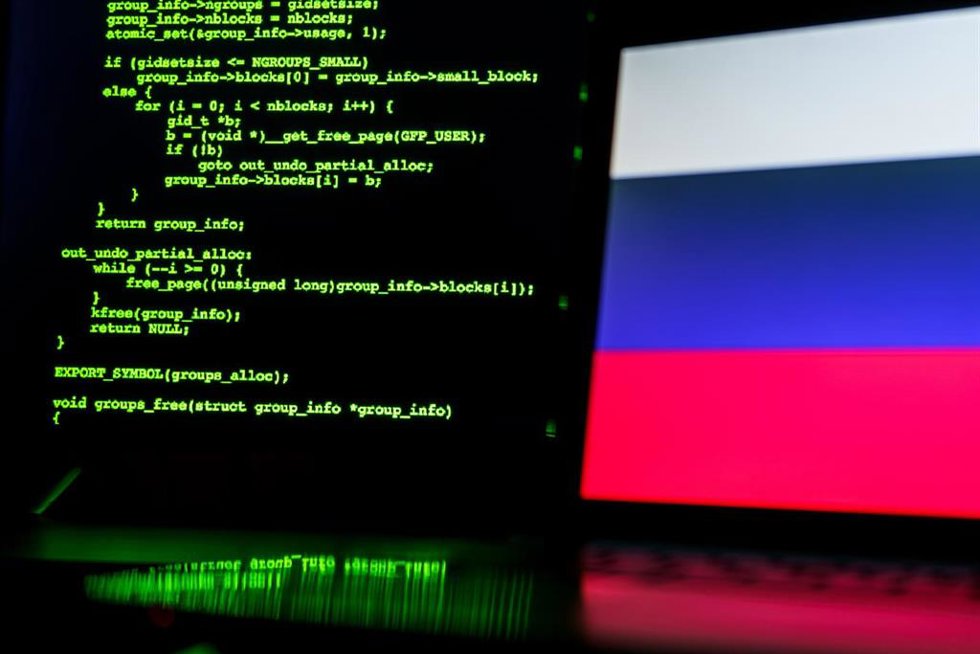 Archivo - Líneas de código informático y una bandera de Rusia