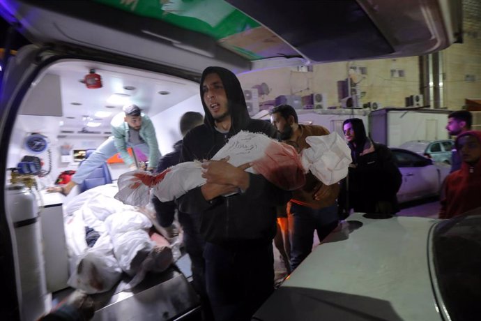 Un hombre traslada el cuerpo sin vida de un familiar, víctima de los ataques de Israel sobre la Franja de Gaza.