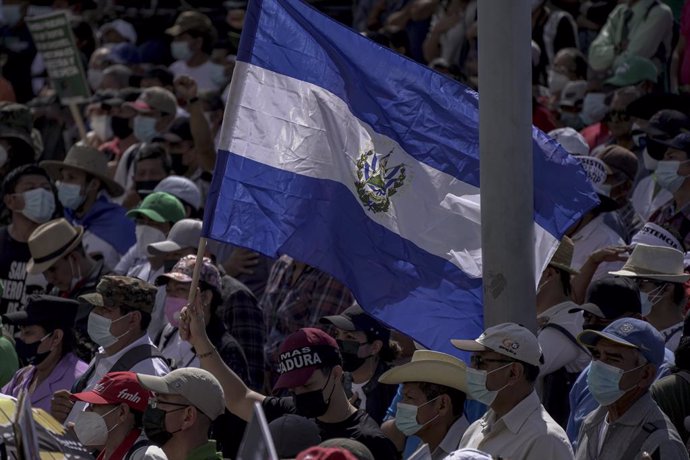 January 16, 2022, San Salvador, El Salvador: A man holds a flag of El Salvador as protesters sing the Salvadoran national anthem during a march of war veterans and social movements to protest against the authoritarian policies of the Salvadoran government