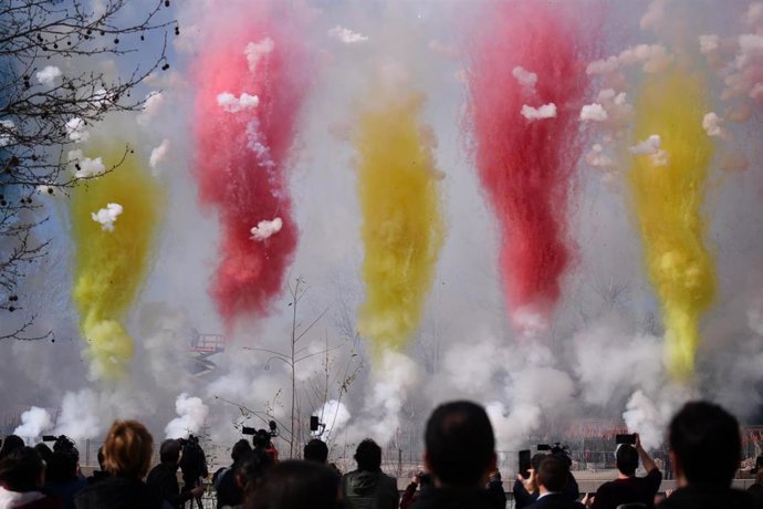 Varias personas observan el humo de colores durante la primera masclet madrileña, en el Puente del Rey de Madrid Río, a 18 de febrero de 2024, en Madrid (España). 