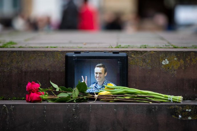 17 February 2024, Baden-Wuerttemberg, Stuttgart: Flowers lie in front of a picture of leading Russian opposition figure Alexei Navalny, who died in prison while serving a 19-year sentence, during a prayer service at Schillerplatz in Stuttgart. Photo: Chri