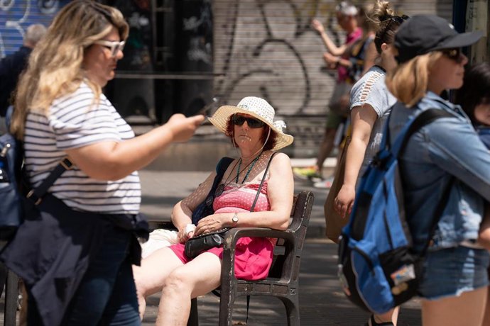 Archivo - Una mujer sentada en un banco en Las Ramblas, a 30 de junio de 2023, en Barcelona, Cataluña (España).