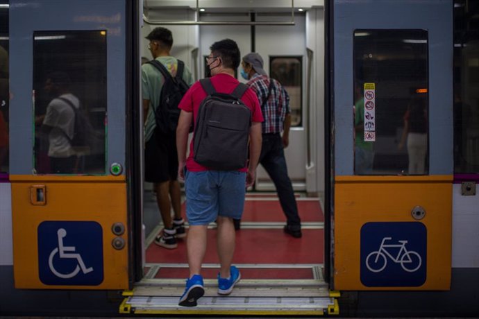 Archivo - Arxiu - Viatgers entren a un tren en un de les andanes de l'estació de Sants