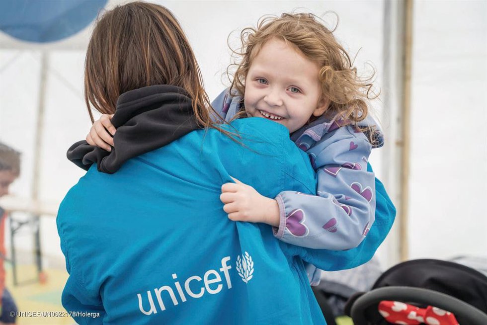 Personal de Unicef con una niña ucraniana en brazos.
