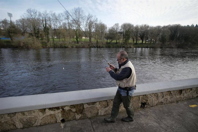 Archivo - Un pescador, lanza la caña en el río, durante el primer día de temporada de pesca fluvial, a 19 de marzo de 2023, en Rábade, Lugo