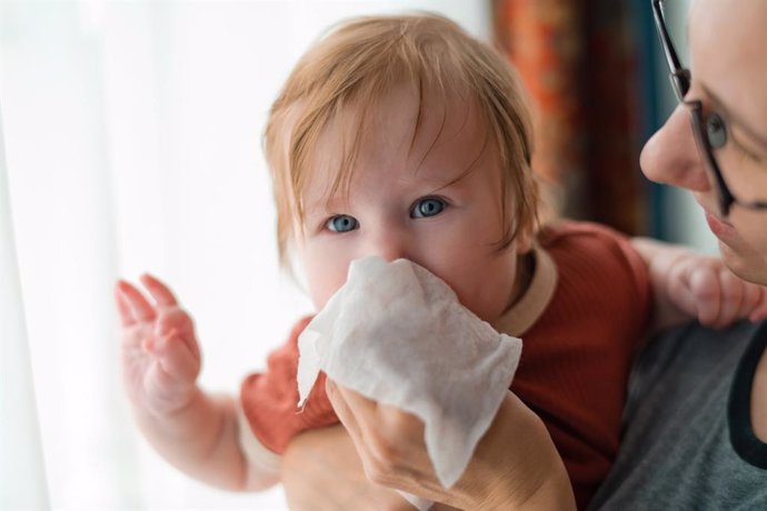 Archivo - Madre limpiando la nariz a su bebé.