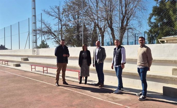 Raquel López (2ª izda) y Miguel Ruz Ruz (centro),  junto a la grada en la sala-multideporte construida con cargo al PFEA en Montalbán.