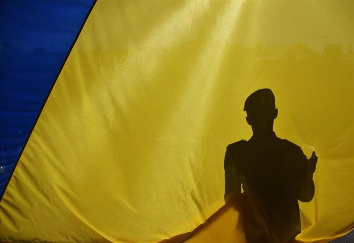 Archivo - Militar ucraniano tras la bandera nacional durante el Día de la Constitución