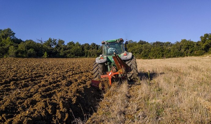 Archivo - Imagen de archivo de un tractor arando en el campo.