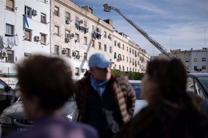 Varias personas observan el trabajo de los operativos de emergencias tras el derrumbe de un edificio en Badalona.