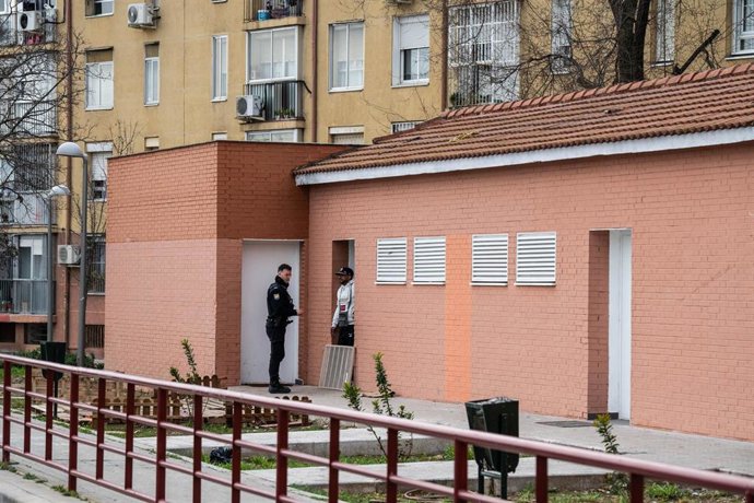 Un agente de Policía Nacional conversa con un hombre que duerme en los 'narcovestuarios' okupados del distrito de San Blas
