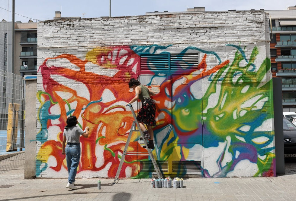 Dos artistas pintando el centro de transformación que hay en la calle Gasmetre