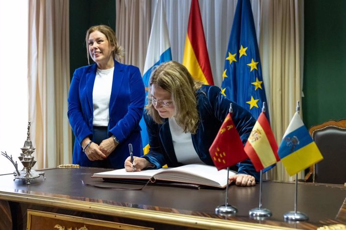 La presidenta de la Asamblea de Murcia, Visitación Martínez, firma en el Libro de Honor del Parlamento de Canarias ante la mirada de la presidenta canaria, Astrid Pérez